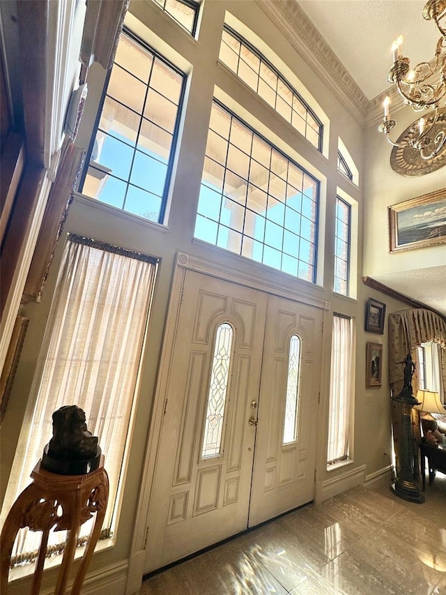 132 Pleasant Valley Dr, Daytona Beach, FL 32114 - entrance foyer featuring a high ceiling, a healthy amount of sunlight, a chandelier, and crown molding