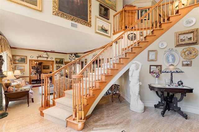 132 Pleasant Valley Dr, Daytona Beach, FL 32114 - stairs with visible vents, a high ceiling, baseboards, and ornamental molding