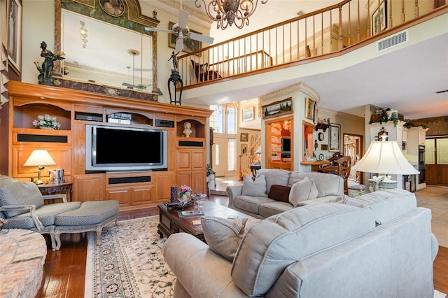132 Pleasant Valley Dr, Daytona Beach, FL 32114 - living area featuring visible vents, ornamental molding, ceiling fan with notable chandelier, wood finished floors, and a towering ceiling