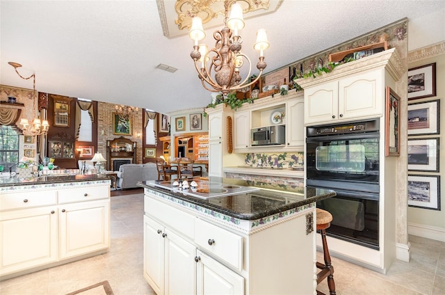 132 Pleasant Valley Dr, Daytona Beach, FL 32114 - kitchen featuring visible vents, dobule oven black, stainless steel microwave, a notable chandelier, and a large fireplace