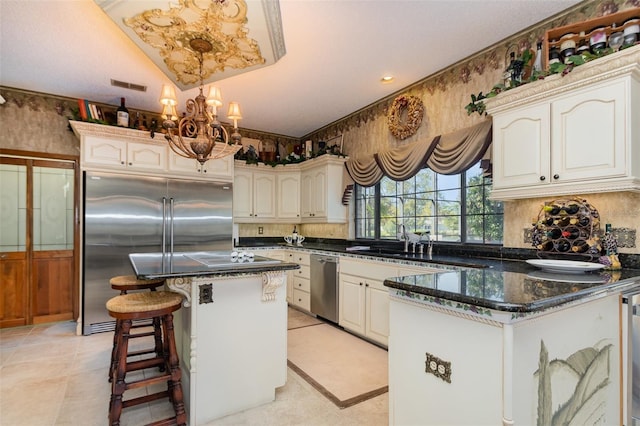 132 Pleasant Valley Dr, Daytona Beach, FL 32114 - kitchen featuring visible vents, a kitchen bar, a peninsula, a notable chandelier, and stainless steel appliances
