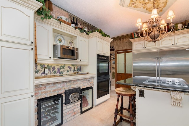 132 Pleasant Valley Dr, Daytona Beach, FL 32114 - kitchen with appliances with stainless steel finishes, an inviting chandelier, light tile patterned flooring, a textured ceiling, and open shelves