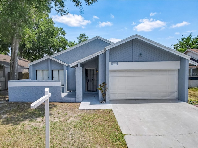 2253 Atrium Cir, Orlando, FL 32808 - mid-century home featuring a garage, driveway, stucco siding, and fence