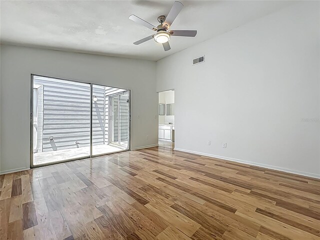 2253 Atrium Cir, Orlando, FL 32808 - spare room with wood finished floors, a ceiling fan, and baseboards