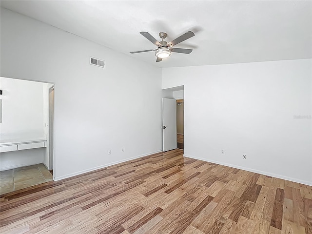 2253 Atrium Cir, Orlando, FL 32808 - spare room featuring wood finished floors, ceiling fan, lofted ceiling, and baseboards