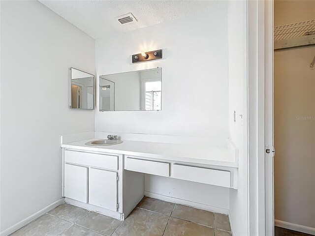 2253 Atrium Cir, Orlando, FL 32808 - bathroom with tile patterned flooring, vanity, a textured ceiling, and baseboards