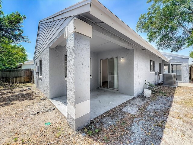 2253 Atrium Cir, Orlando, FL 32808 - view of home's exterior featuring stucco siding, cooling unit, a patio area, and fence