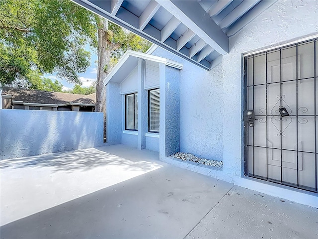 2253 Atrium Cir, Orlando, FL 32808 - doorway to property with stucco siding, a patio, and fence