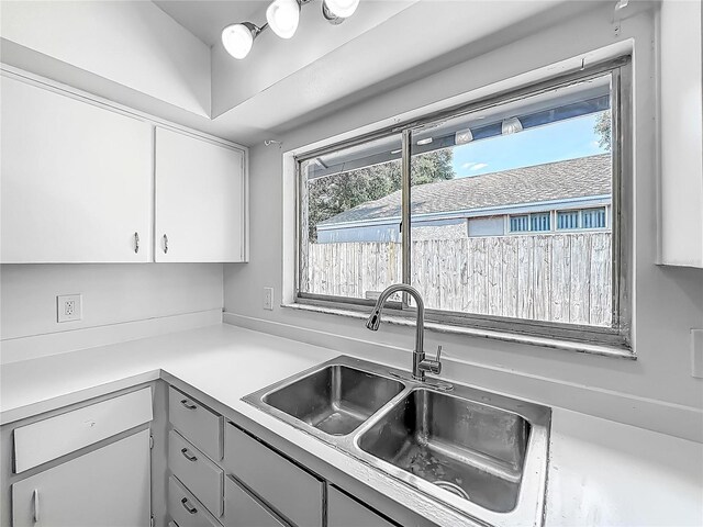 2253 Atrium Cir, Orlando, FL 32808 - kitchen featuring a sink, light countertops, white cabinetry, and gray cabinetry