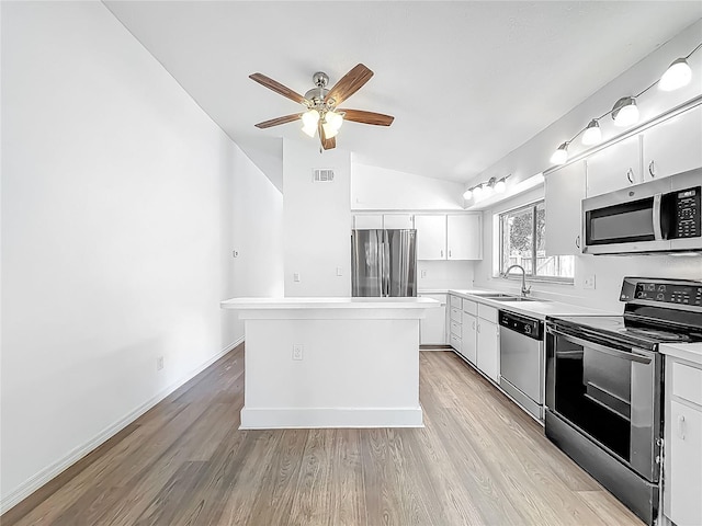 2253 Atrium Cir, Orlando, FL 32808 - kitchen featuring appliances with stainless steel finishes, a sink, lofted ceiling, light wood-type flooring, and a ceiling fan