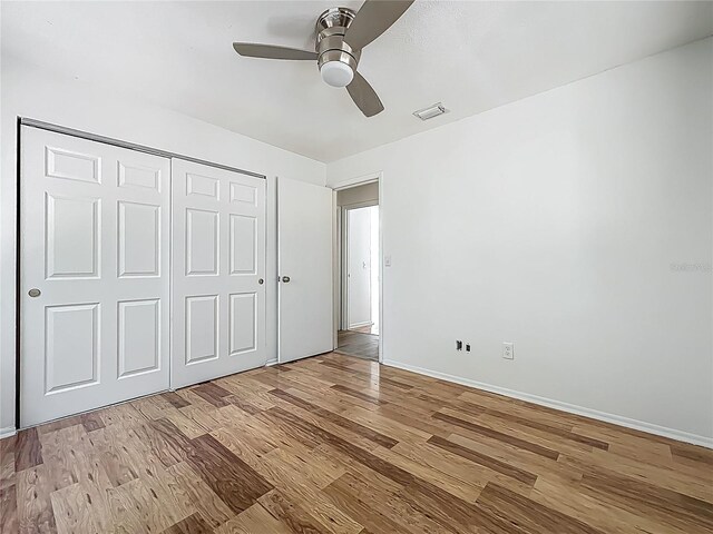 2253 Atrium Cir, Orlando, FL 32808 - unfurnished bedroom featuring wood finished floors, a closet, baseboards, and a ceiling fan