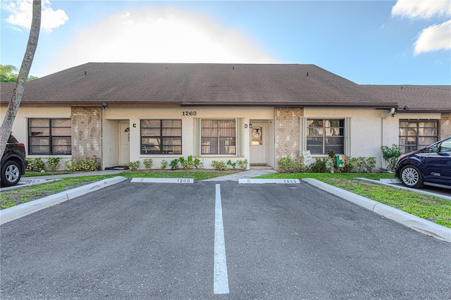 1260 Parkside Green Dr Unit D, Greenacres, FL 33415 - exterior space with uncovered parking, brick siding, and a shingled roof