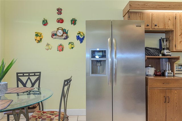 1260 Parkside Green Dr Unit D, Greenacres, FL 33415 - kitchen featuring brown cabinetry, baseboards, and stainless steel fridge with ice dispenser