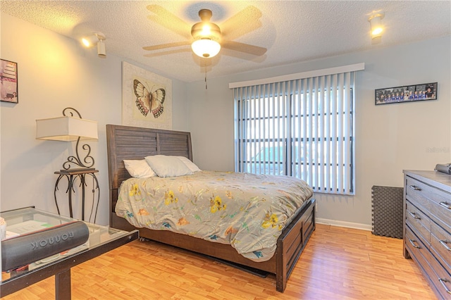 1260 Parkside Green Dr Unit D, Greenacres, FL 33415 - bedroom with baseboards, light wood-style floors, a ceiling fan, and a textured ceiling