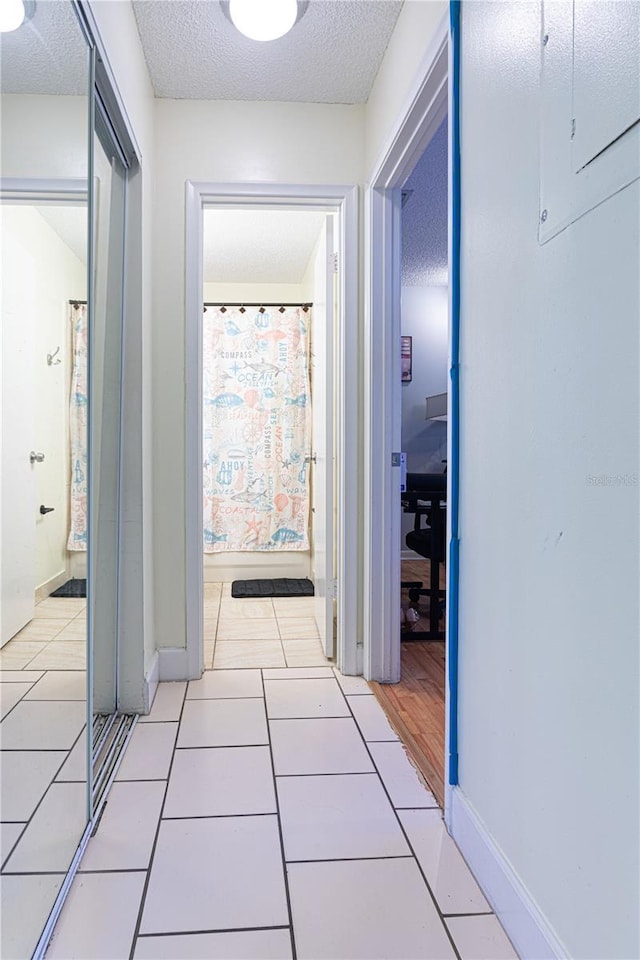 1260 Parkside Green Dr Unit D, Greenacres, FL 33415 - hall with light tile patterned floors, a textured ceiling, and baseboards