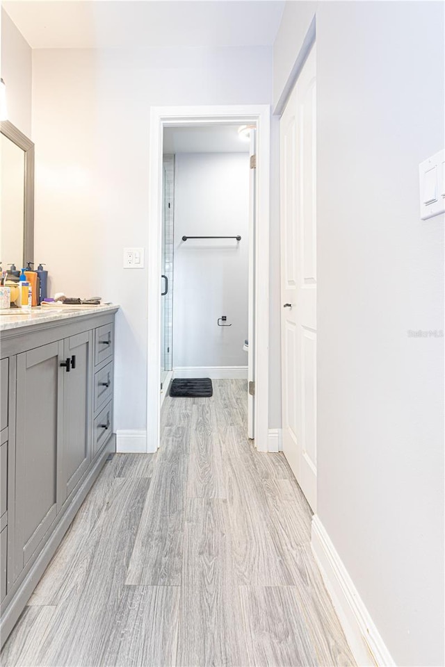 1260 Parkside Green Dr Unit D, Greenacres, FL 33415 - bathroom featuring vanity, wood finished floors, a stall shower, and baseboards