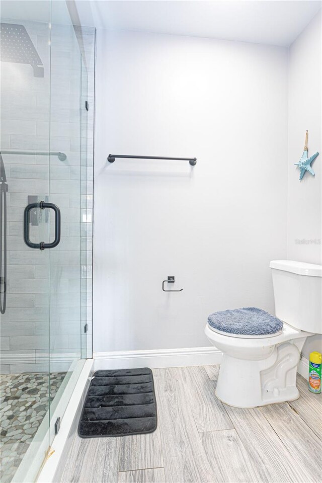 1260 Parkside Green Dr Unit D, Greenacres, FL 33415 - bathroom with wood finish floors, baseboards, toilet, and a stall shower