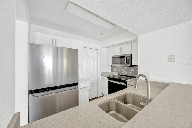 2314 Midtown Ter Unit 1136, Orlando, FL 32839 - kitchen featuring tasteful backsplash, light stone counters, stainless steel appliances, white cabinetry, and a sink