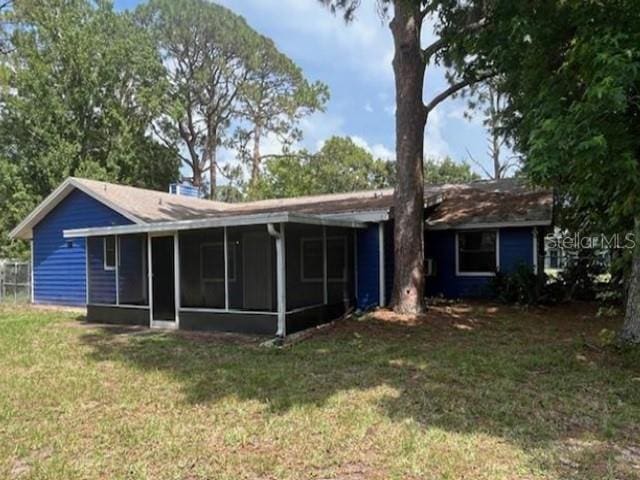 271 Naylor St NE, Palm Bay, FL 32907 - back of property featuring a sunroom and a lawn