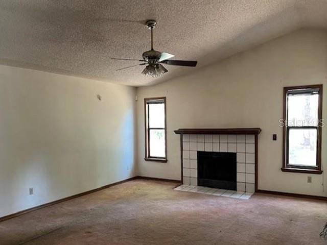 271 Naylor St NE, Palm Bay, FL 32907 - unfurnished living room featuring carpet flooring, a textured ceiling, ceiling fan, baseboards, and a tiled fireplace