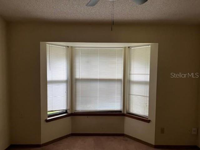 271 Naylor St NE, Palm Bay, FL 32907 - spare room with a textured ceiling, a ceiling fan, and baseboards