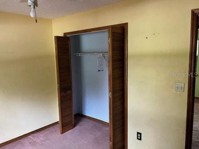 271 Naylor St NE, Palm Bay, FL 32907 - unfurnished bedroom featuring a closet, carpet flooring, a textured ceiling, and baseboards