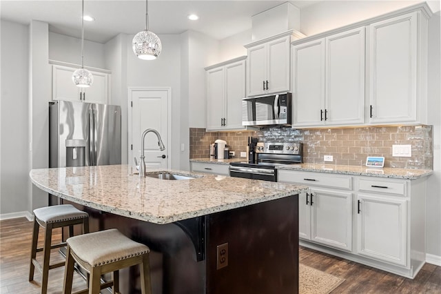 4622 Eureka Ln, Sanford, FL 32773 - kitchen with a center island with sink, a sink, backsplash, dark wood-style floors, and stainless steel appliances