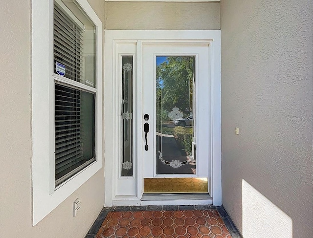 view of exterior entry featuring stucco siding