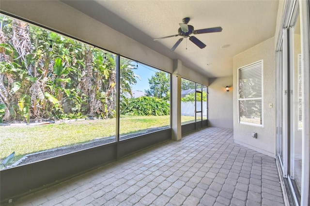 unfurnished sunroom with a ceiling fan