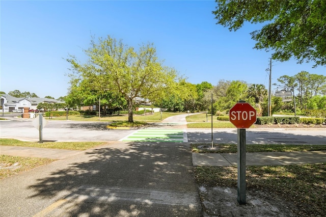 view of road featuring traffic signs and sidewalks