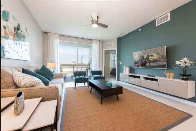 living area featuring visible vents and ceiling fan