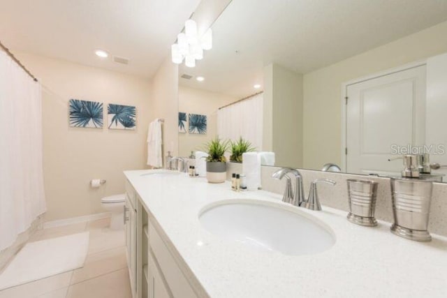 full bathroom featuring tile patterned floors, double vanity, toilet, and a sink