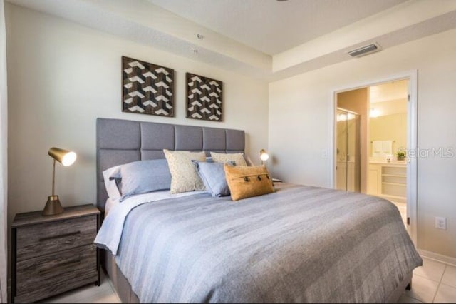 bedroom featuring light tile patterned floors, visible vents, and connected bathroom
