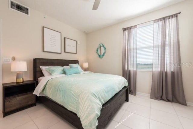 bedroom with light tile patterned floors, visible vents, baseboards, and ceiling fan
