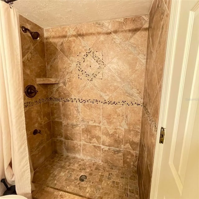 bathroom with a textured ceiling and a stall shower
