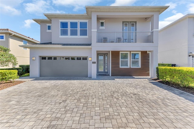 501 Burma St, Kissimmee, FL 34747 - view of front of home featuring stucco siding, french doors, decorative driveway, a garage, and a balcony