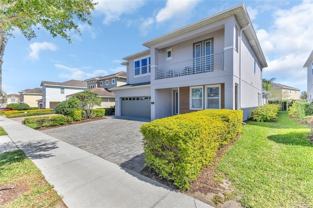 501 Burma St, Kissimmee, FL 34747 - view of front of home featuring a balcony, stucco siding, a garage, decorative driveway, and a residential view