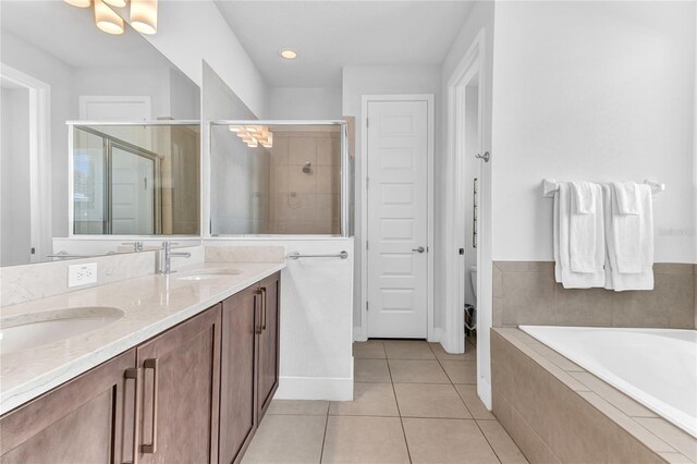 501 Burma St, Kissimmee, FL 34747 - bathroom featuring a stall shower, a sink, tile patterned flooring, double vanity, and a bath