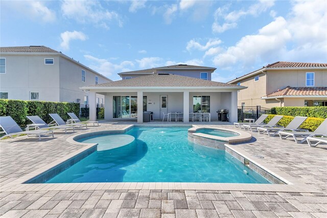 501 Burma St, Kissimmee, FL 34747 - view of swimming pool featuring a pool with connected hot tub, a patio, and fence