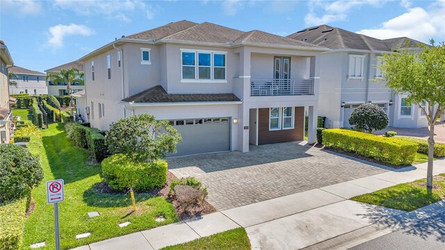 501 Burma St, Kissimmee, FL 34747 - view of front of house featuring an attached garage, a front yard, stucco siding, a balcony, and driveway