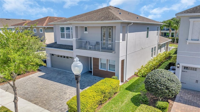 501 Burma St, Kissimmee, FL 34747 - view of front facade featuring stucco siding, decorative driveway, a balcony, and an attached garage