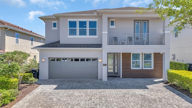 501 Burma St, Kissimmee, FL 34747 - view of front of property featuring roof with shingles, stucco siding, decorative driveway, a balcony, and a garage