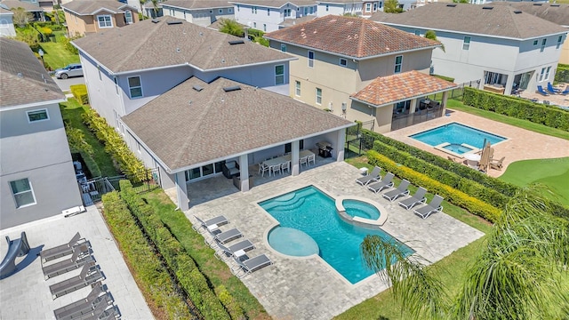 501 Burma St, Kissimmee, FL 34747 - exterior space featuring outdoor dry bar, a pool with connected hot tub, a patio, fence, and a residential view
