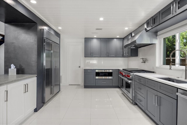 7841 Georgeann St, Winter Park, FL 32792 - kitchen featuring high quality appliances, a sink, wall chimney range hood, gray cabinetry, and recessed lighting