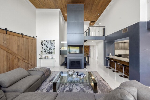 7841 Georgeann St, Winter Park, FL 32792 - tiled living room with wood ceiling, a towering ceiling, ornamental molding, a barn door, and a fireplace