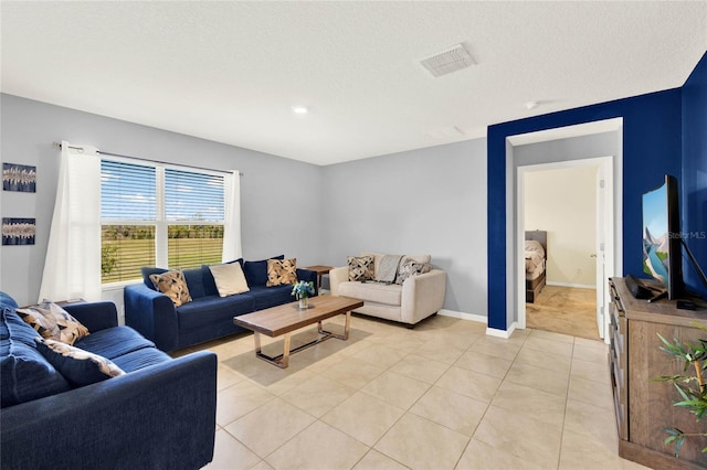 11207 Amber Ridge Dr, Zellwood, FL 32798 - living area featuring light tile patterned flooring, visible vents, a textured ceiling, and baseboards