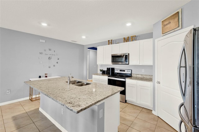 11207 Amber Ridge Dr, Zellwood, FL 32798 - kitchen with an island with sink, a sink, light tile patterned floors, and appliances with stainless steel finishes