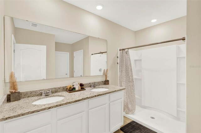 11207 Amber Ridge Dr, Zellwood, FL 32798 - bathroom with visible vents, a sink, a shower with shower curtain, and double vanity