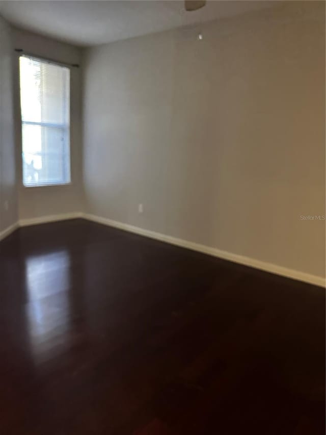 860 N Orange Ave Unit 149, Orlando, FL 32801 - spare room featuring baseboards and dark wood finished floors