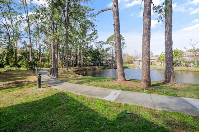 view of community with a lawn and a water view